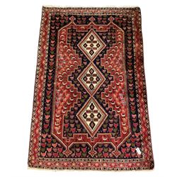 Persian indigo and crimson ground rug, the field with extending triple lozenge medallion, profusely decorated with bird motifs, triple band border with geometric design