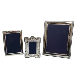 Three modern silver mounted photograph frames, the largest example of plain rectangular form with beaded edge, hallmarked Carr's of Sheffield Ltd, Sheffield 2015, overall H21.5cm, the second of plain form, hallmarked Mappin & Webb Ltd, Sheffield 1989, H16cm, and the smallest of shaped form with repoussé decoration, hallmarked Keyford Frames Ltd, London 1984, H13cm, (3)