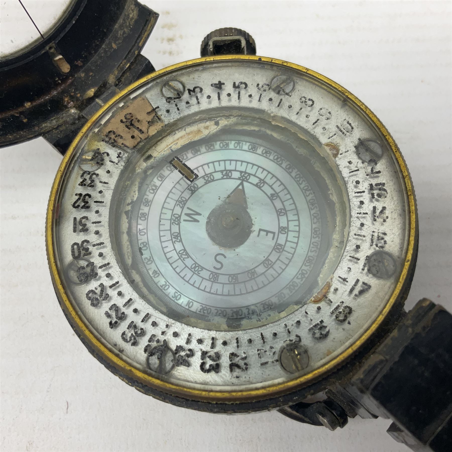 WWII British marching compass, the black lacquered brass case inscribed T.G.Co.Ltd. No.B100228 (broad arrow) 1941 Mk.III; and a ship's brass cased clinometer, the silvered dial marked R(arrow)L, D9cm; in leather carrying case (2)