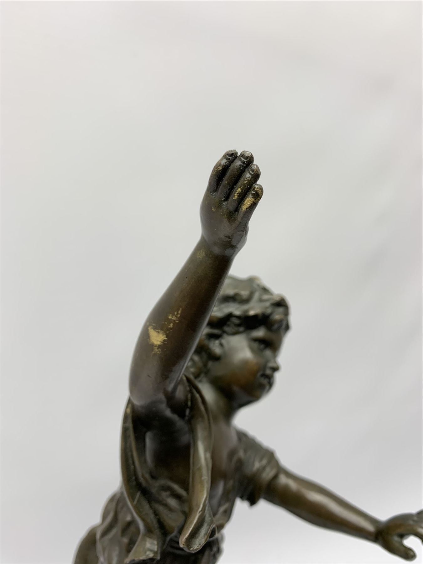 After E Plat, bronze modelled as a dancing child, signed E. Plat, upon cylindrical black marble base, H40cm