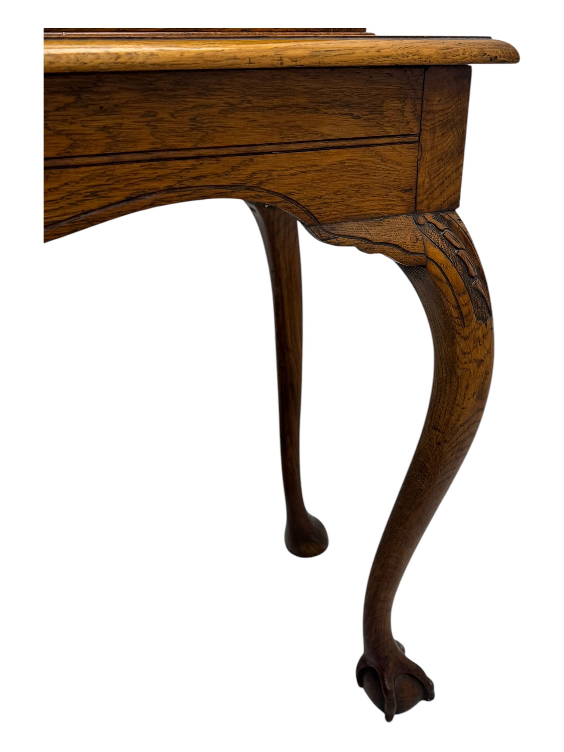 Late 19th century oak display cabinet, rectangular form with a pair of glazed doors enclosing shelves, raised on cabriole supports with carved detailing ending in claw feet