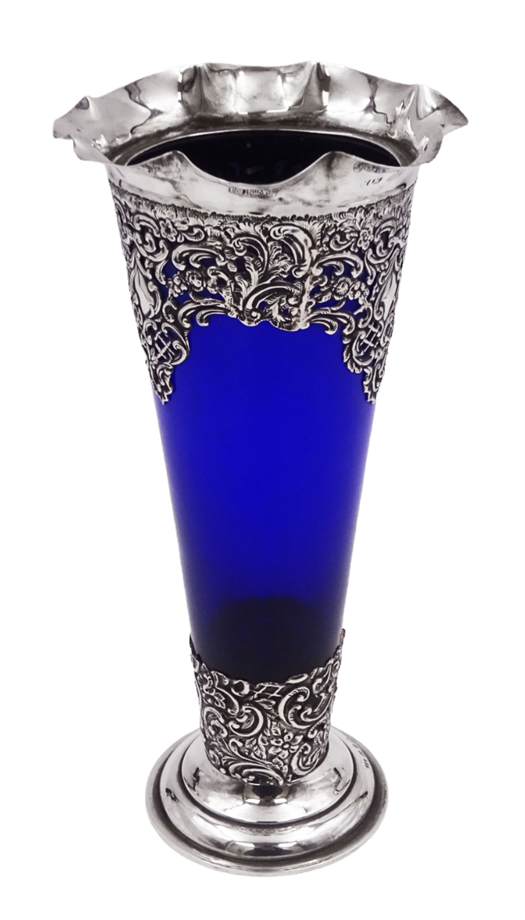 Victorian silver mounted blue glass trumpet vase, the silver mounts with pierced and embossed floral, C scroll and lattice decoration, with frilled rim, upon stepped circular foot, hallmarked Henry Matthews, Birmingham 1899