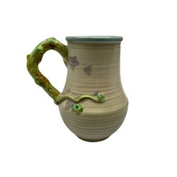 Clarice Cliff baluster jug moulded with a blue budgerigar perched upon branch with green rustic handle and mushroom glaze,  factory stamped beneath, H22.5cm