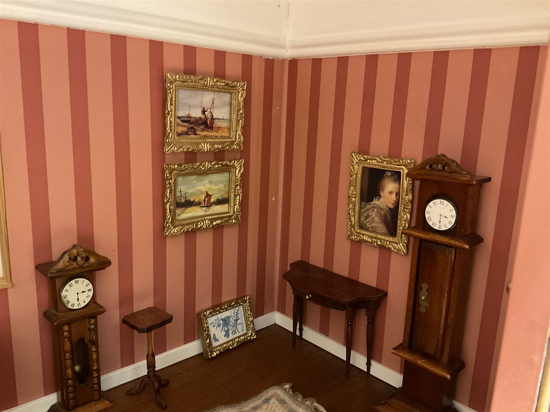 Good quality late 20th century dolls house by M. James dated 1995 in the form of a Beverley East Yorkshire Antique Shop called 'North Bar Antiques'; single-storey single-roomed shop with textured brick walls and flat roof, fully glazed hinged front with recessed hinged customer door and central window to the rear; comprehensively furnished with chests of drawers, pedestal desk, breakfast table, lowboy, two longcase clocks, delft rack with ceramics, occasional tables, pictures, Regency style mirror and collectibles; decorated walls with coving and picture rail and simulated floorboarding; wired for electric lighting; maker's plaque W61cm H42.5cm D41.5cm