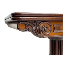 Early Victorian mahogany tea table, the rectangular fold-over top with figured band, the frieze with scrolled and foliate carved decoration, octagonal column mounted with multiple cluster columns, platform base with scroll feet