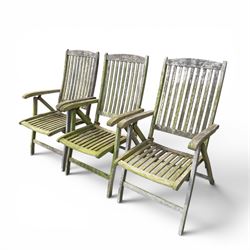 Five piece teak garden dining set, comprising circular folding table and four folding armchairs, with slatted seats and backs in a weathered finish