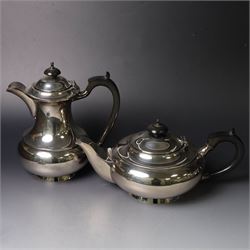 Mid 20th century silver four piece tea service, comprising teapot, hot water pot, open sucrier and milk jug, all of squat bellied form, the teapot and hot water pot with ebonised handles and finials, hallmarked Walker & Hall, Sheffield 1953, hot water pot H19cm