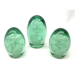  A pair of Victorian green glass dump paperweights, together with another larger Victorian example, each with internal floral decoration, pair H11cm, tallest H13.5cm.   