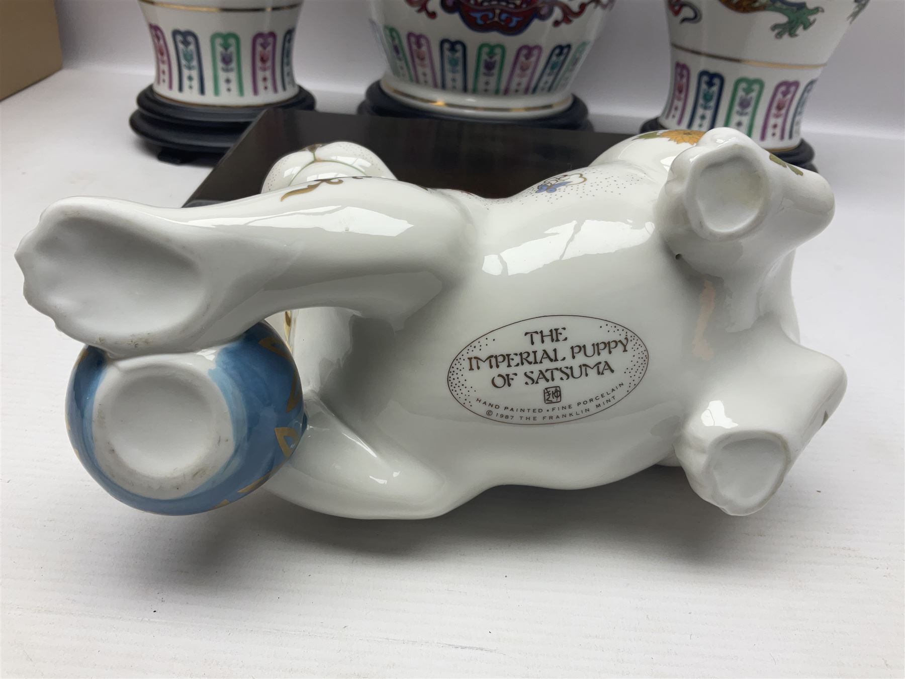 Franklin Mint Chinese style ceramics, comprising two vases, puppy and a planter, all on wooden stands