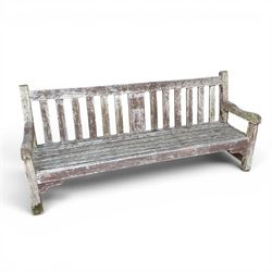 Teak garden bench with slatted back and seat on square supports in weathered which finish 