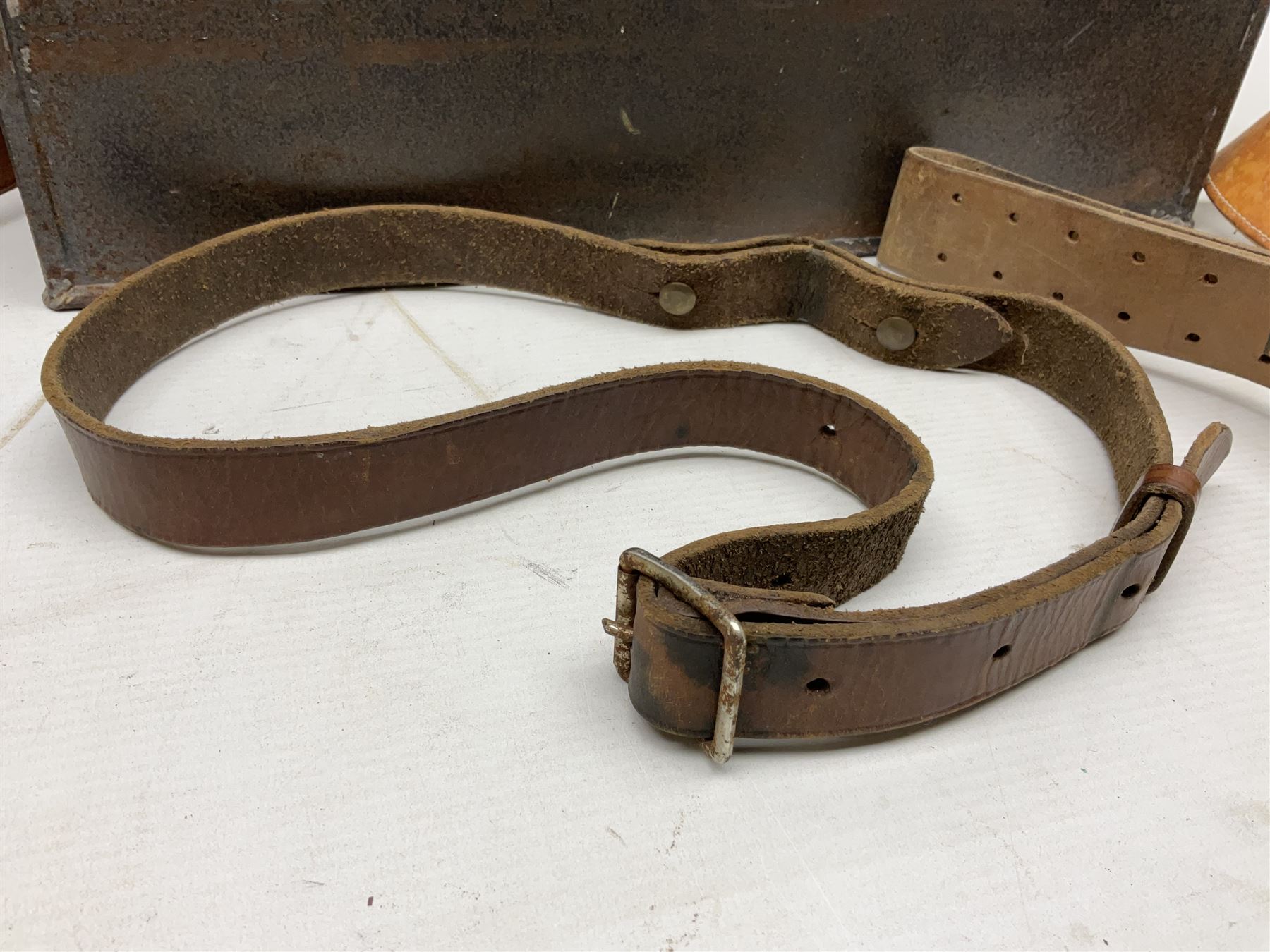 Assorted militaria including ten leather or canvas cartridge and other belts, maroon beret with 17th Lancers cap badge, modern bullet mould, leather and brass shot flask, two knives, shell cases, boomerang etc; in tin deed box