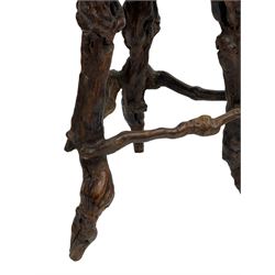 Mid-20th century French grapevine and walnut bow-front wine tasting bar, the curved counter top supported by sculptural grapevine roots, fitted with single shelf and raised on rustic vine feet (W100cm H101cm); with a pair of matching bar stools, the circular top raised on three gnarled root supports united by stretchers (W50cm H70cm)