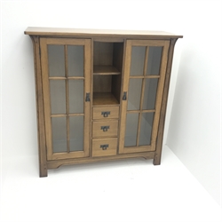  Arts & Crafts style oak cabinet, two glazed doors flanking single shelf and three graduating drawers, stile supports, W130cm, H134cm, D41cm  