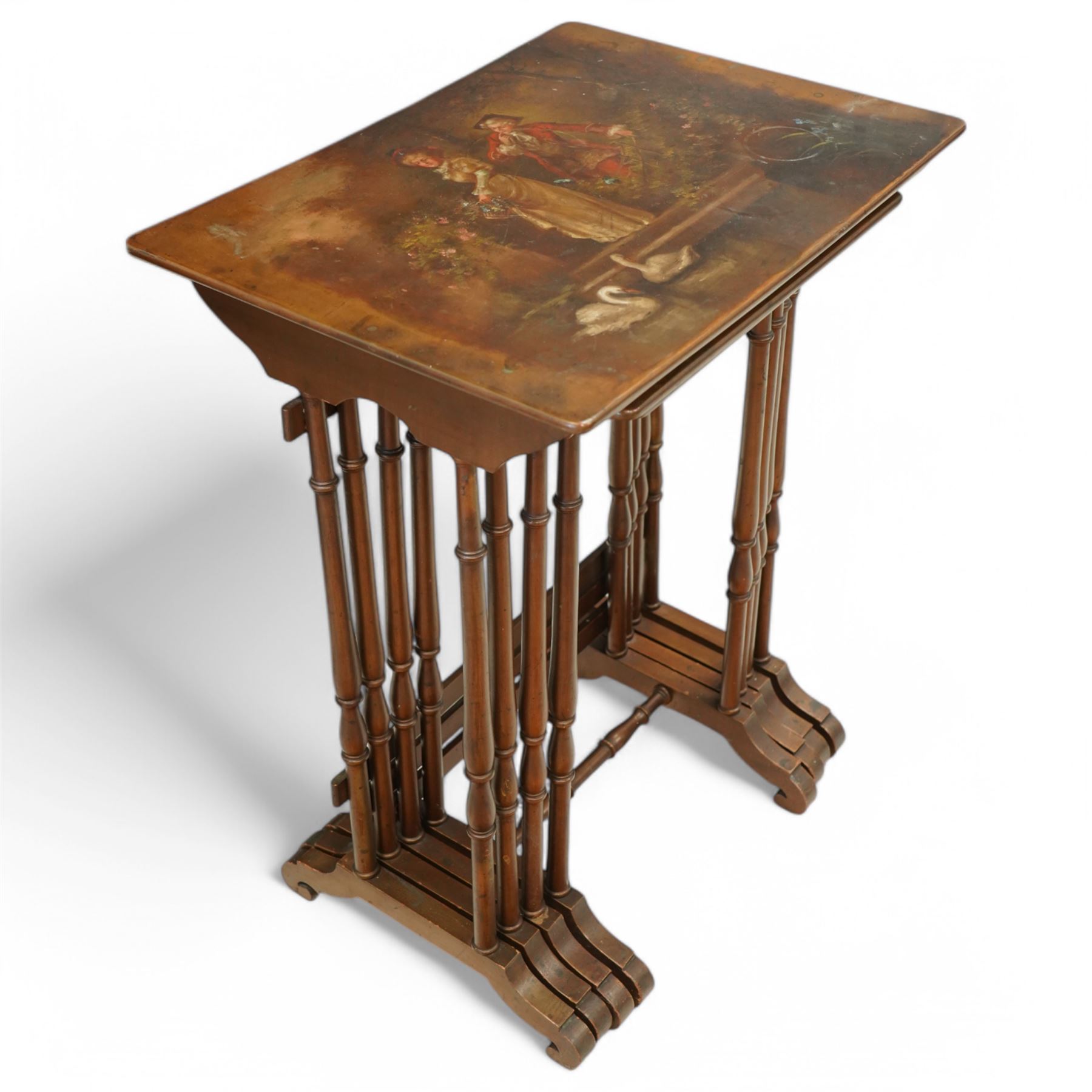 French 19th century painted nest of tables, the largest depicting a romantic scene of courting lovers by a swan lake, indistinctly signed L Desi**, the smaller tables painted with rural landscapes, the painted rectangular tops raised on ring turned end supports united by stretcher