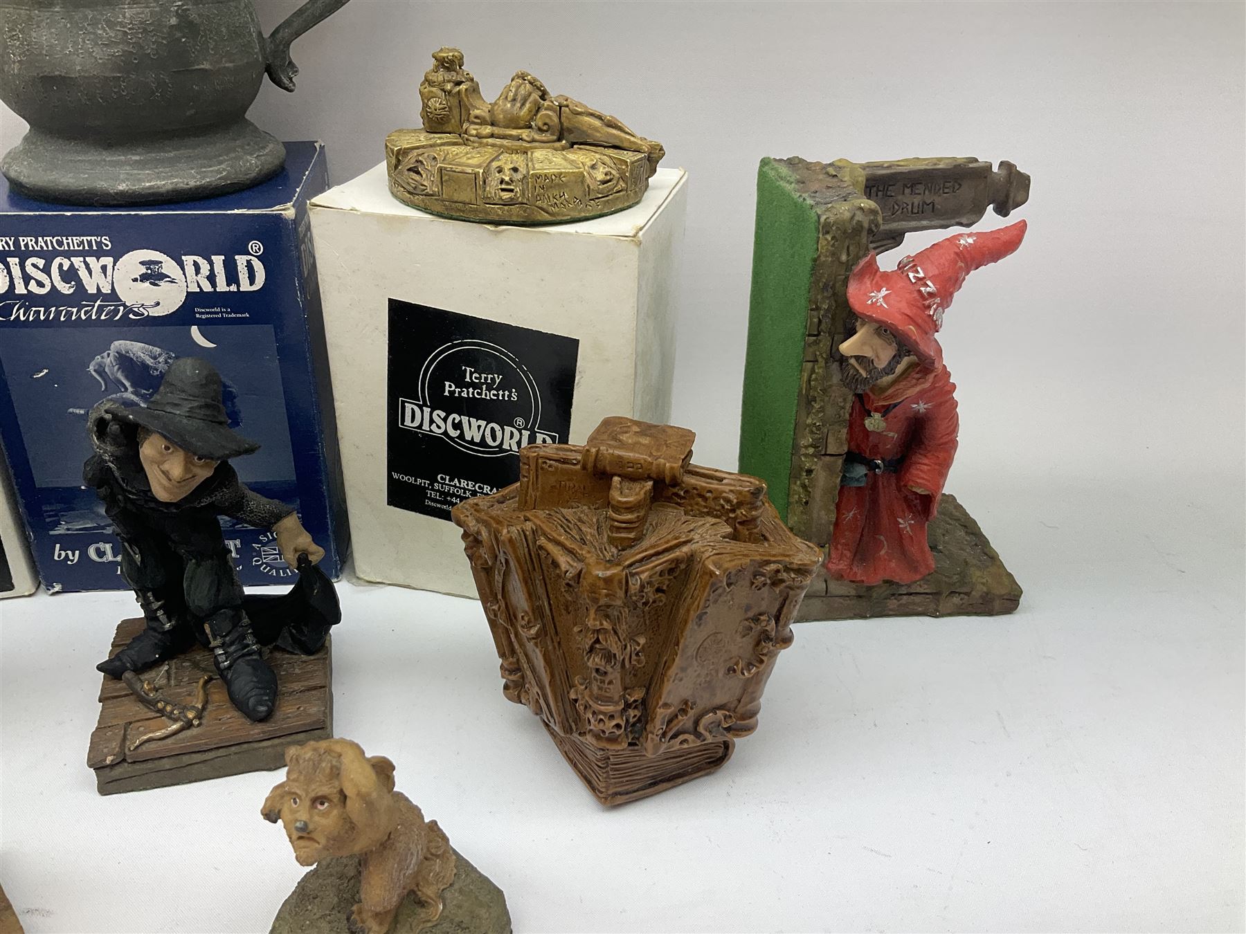 Terry Pratchett Discworld figures, comprising Roderick the hippo, DWE2, a 1995 event piece, Rincewind bookend, DW11, Death bookend, DW12, Librarians wizard knob, boxed, DW55, the luggage, boxed, DW04, tankard from the mended drum, DW21, Teppic the assassin, DW32, Greebo, DW45, Herne the hunted, DW64, Gaspode,  DW31, Quoth on skull, DW49 and Dibbler's compass DW16. 