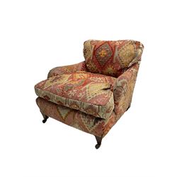 Early 20th century Howard style armchair, upholstered in Kilim fabric with sprung seat, hardwood frame, square tapering supports with brass and ceramic castors