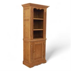Contemporary stripped pine bookcase cabinet, the upper section with arched frieze and open...