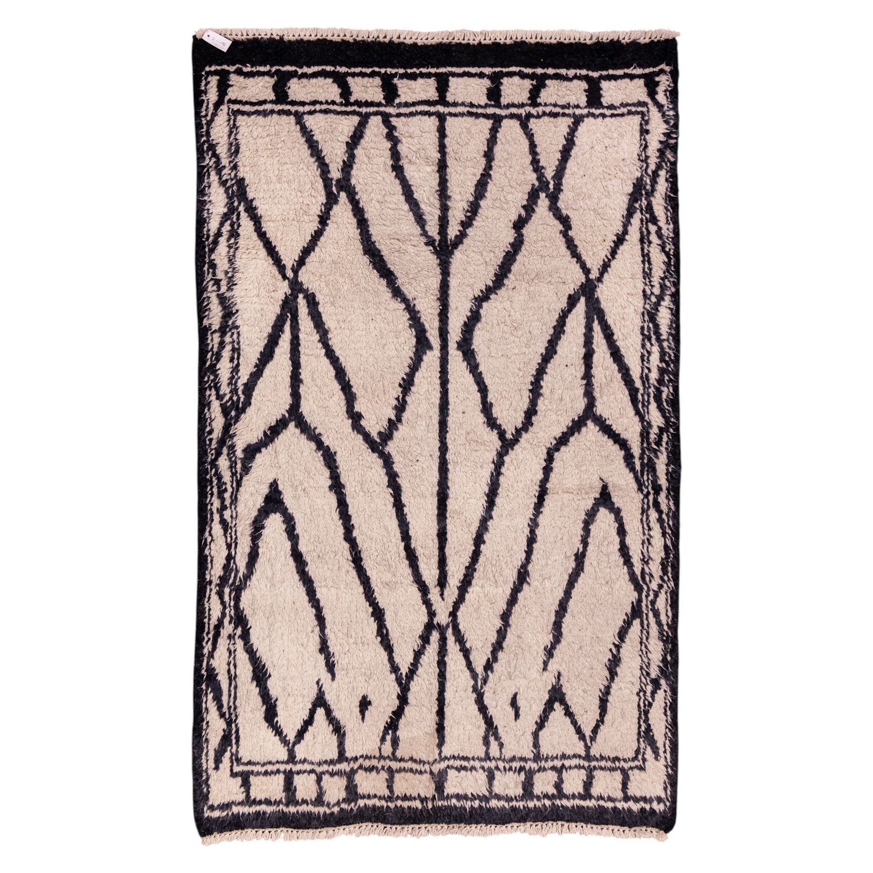 Moroccan Berber wool hand knotted rug, the cream ground decorated with abstract diamond forms and angular lines in dark brown, enclosed by a simple patterned border, with short fringe ends