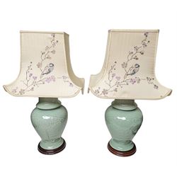 Pair of table lamps of baluster form, in pale blue with a circular wooden base, with embroidered shades, H44cm