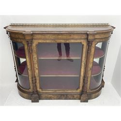 Victorian figured walnut credenza, the curved stepped moulded top with brass gallery above frieze inlaid with box wood motifs, central glazed door flanked by two curved glazed doors, the interior fitted with shelves and lined with red velvet, fluted and acanthus carved column pilasters, figured plinth base