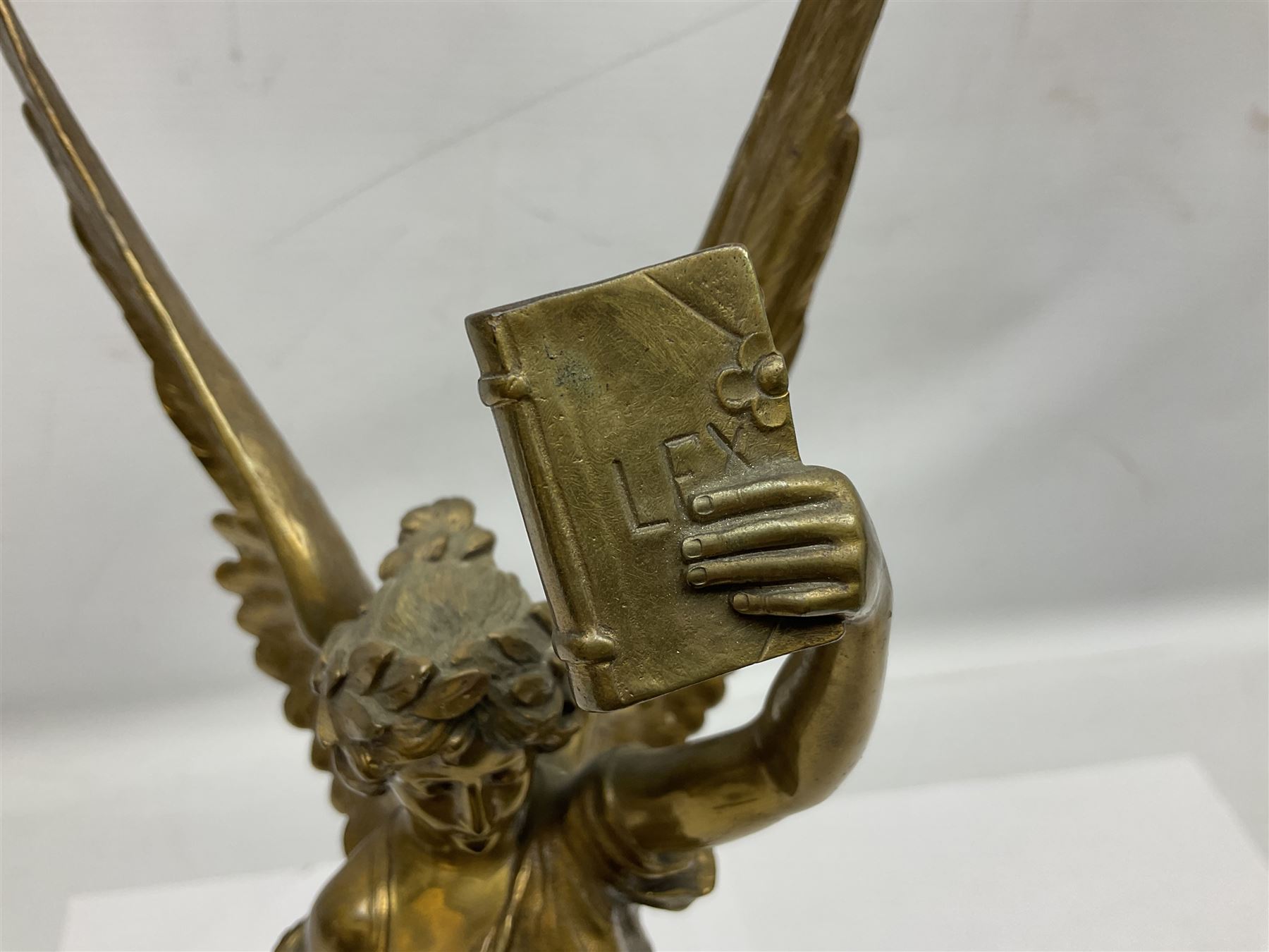 After Oswald Schimmelpfennig (German, 1872-1939): Pair of gilt bronze winged Allegorical female figures, the first example with arm outstretched holding a branch, signed 'Schimmelpfennig 1900', the second with arm raised above her head holding a book and sword in the other, both raised upon marble plinths, H45cm