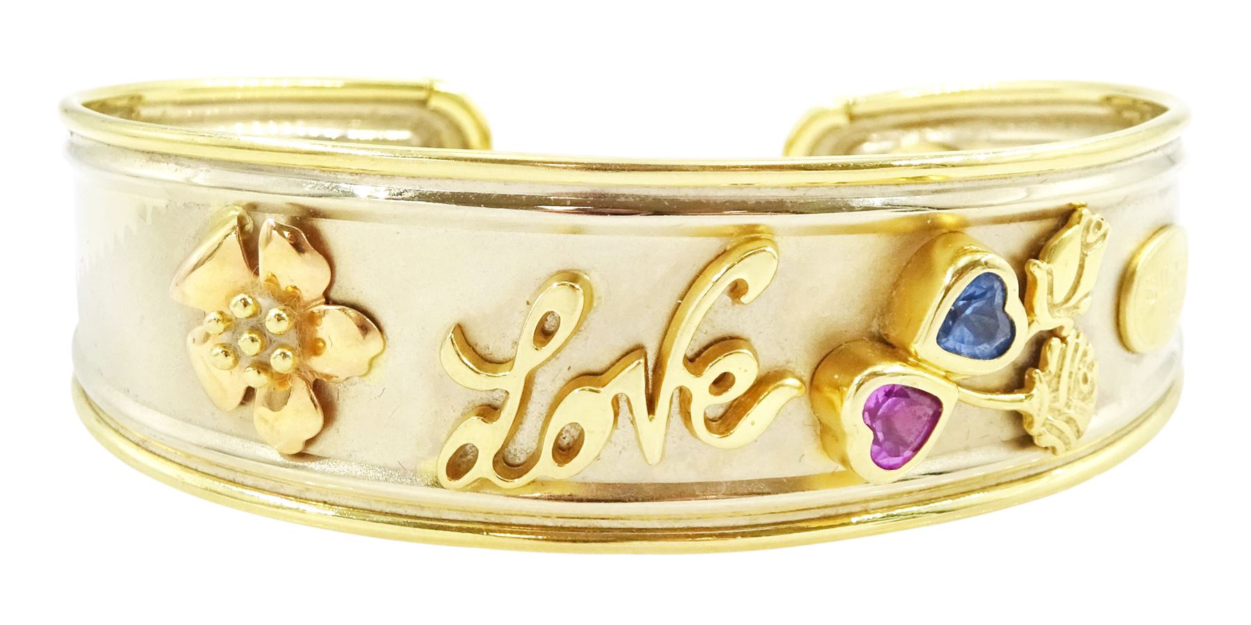 18ct gold 'Love' torque bangle, set with a heart cut pink sapphire and blue topaz, stamped Sidra 750