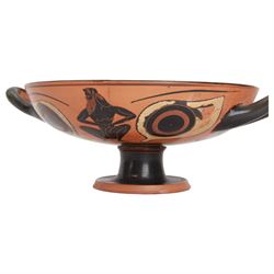 Greek Attic Black-figured eye cup, of typical form with twin handles, the exterior painted with erotic figures flanked by apotropaic eyes, the black interior with reserved tondo with ring dot motif, upon pedestal foot, including handles H9.5cm W28.5cm cup D21.5cm
