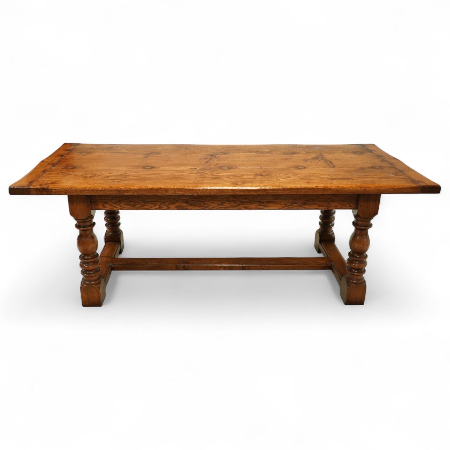 17th century design rustic oak refectory dining table, rectangular plank top over plain frieze rails, raised on heavily turned legs united by an H-stretcher  