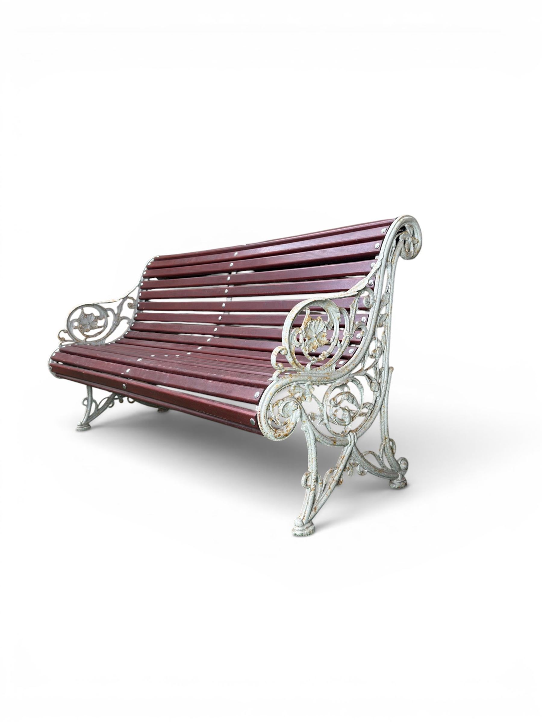 Large late Victorian cast iron garden bench, serpentine form with scroll back and seat, slatted with mahogany stained Sapele