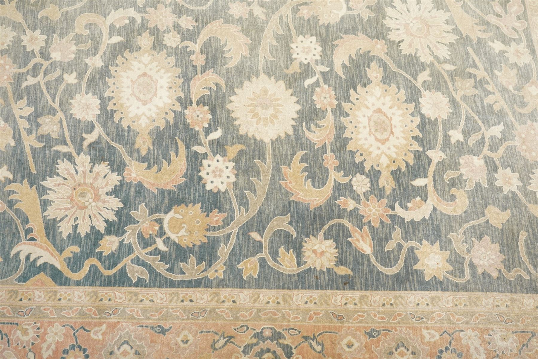 Indo-Persian indigo ground carpet, the field decorated with large palmette motifs connected by scrolling foliate, enclosed nu wide guard bands decorated with repeating interlaced stylised plant motifs
