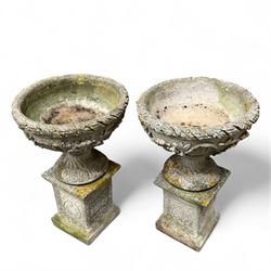 Pair of cast stone ornate garden urns, on plinth bases