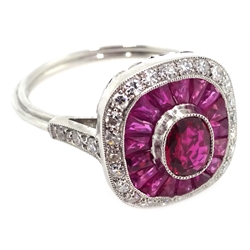  Platinum (tested) ring set with central oval ruby, halo of calibre cut rubies and halo of diamonds, with diamond shoulders  