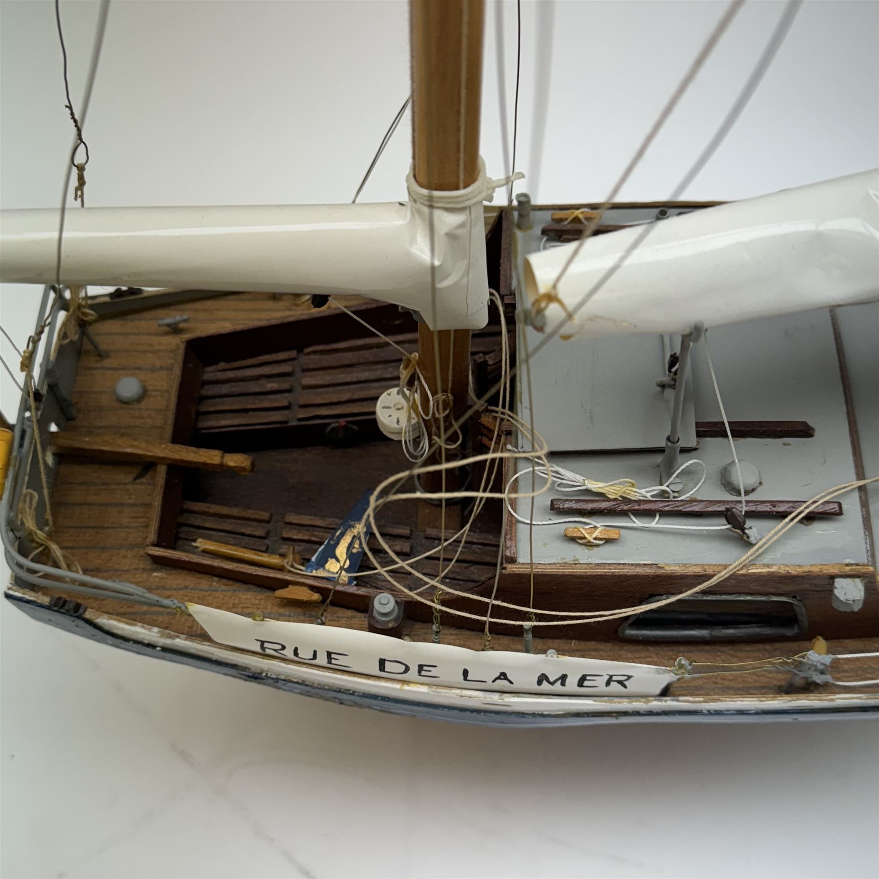 Scratch built model yacht 'Rue de la mer', with painted blue and white hull, with acrylic case, model H67.5cm