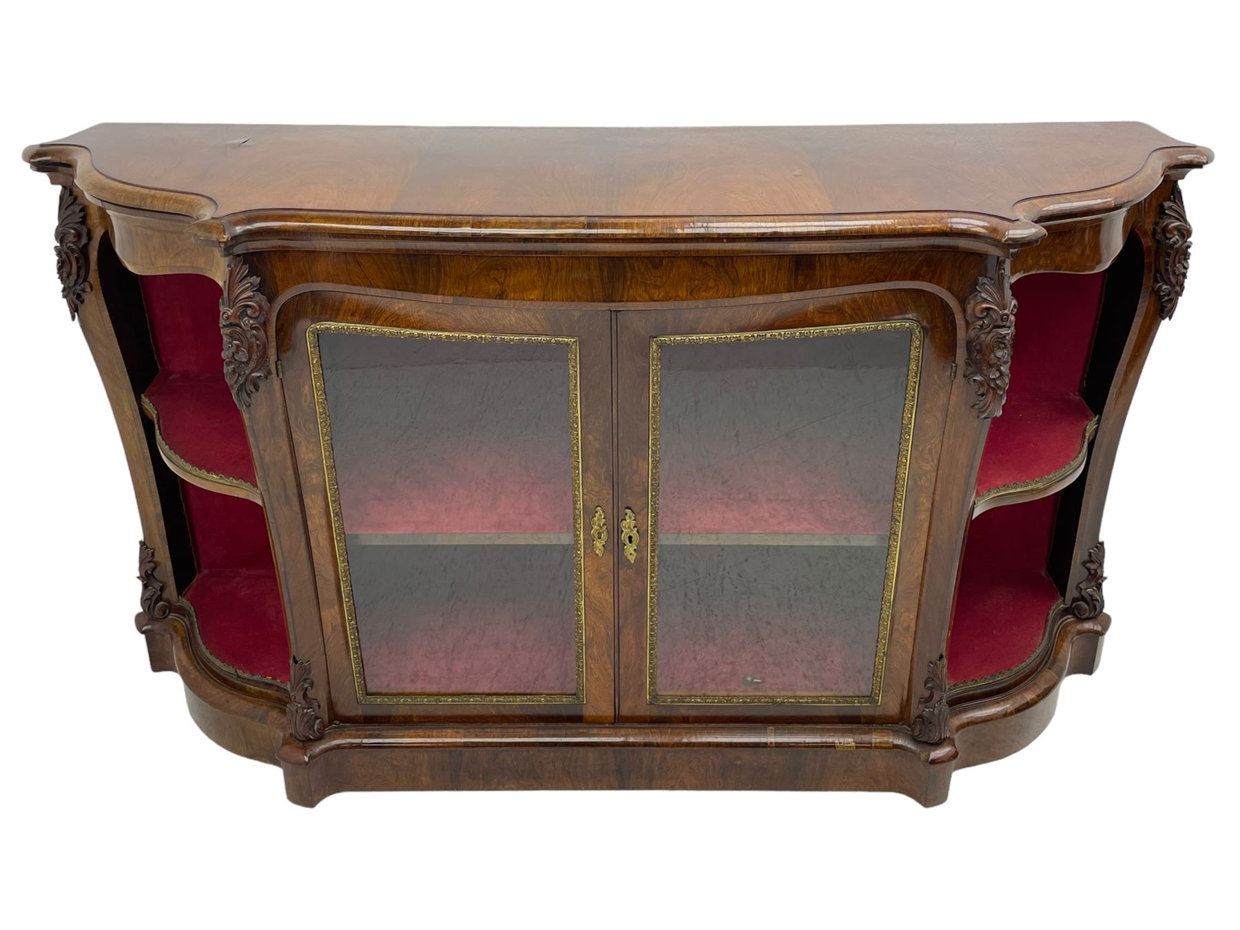 19th century rosewood buffet credenza, bombe form with shaped and moulded top, two central glazed doors with foliate moulded gilt slips, the red fabric-lined interior fitted with a single shelf, flanked by open shelves with raised gilt metal lips, the uprights decorated with shell and flower head carved cartouche mounts, acanthus leaf scroll carved lower mounts, on shaped and moulded plinth base 