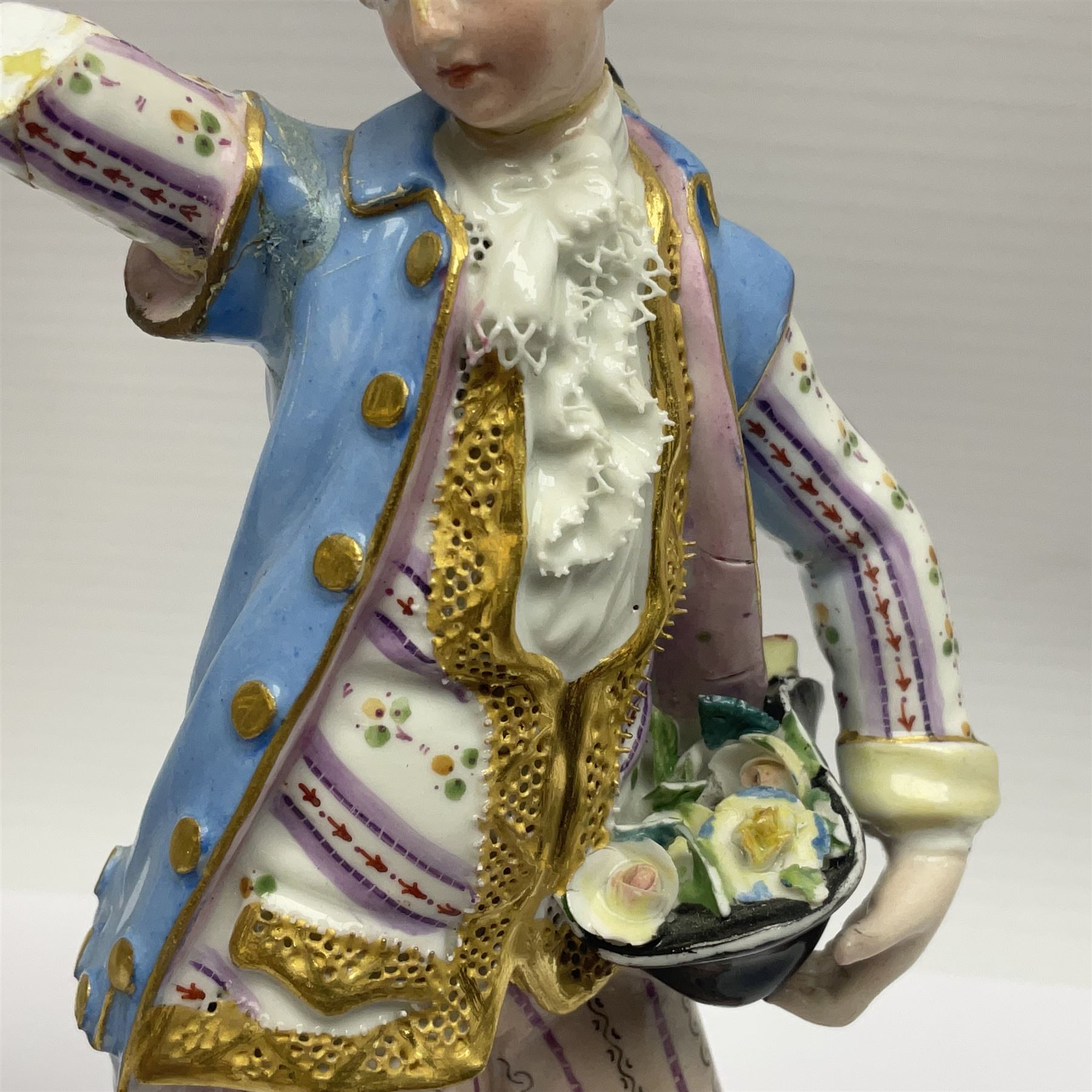 Pair of late 19th/early 20th Century Meissen figures, modelled as flower sellers, after the original by Michel Victor Acier, she holding basket of flowers, he holding flowers in his hat, each with underglaze cross swords mark beneath, tallest H16.5cm