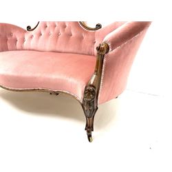 Victorian walnut serpentine framed settee, floral and scroll carving, upholstered in light rose buttoned fabric and detailed trim, shell carved supports and castors 
