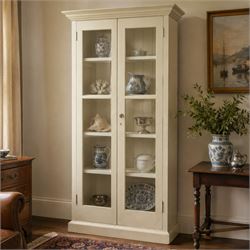 Traditional white painted pine display cabinet, projecting cornice above two glazed doors ...