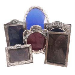 Six modern silver mounted photograph frames, to include an oval example, decorated with doves and green man masks, hallmarked W I Broadway & Co, Birmingham 1985, and a rectangular example with crossed golf club decoration, hallmarked Carr's of Sheffield Ltd, Sheffield 1994 etc, largest H24cm