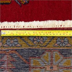 Turkish Anatolian hand-knotted carpet, red field centred by a large pale blue geometric medallion flanked by pink octagonal medallions, scattered stylised motifs, enclosed by multiple geometric borders