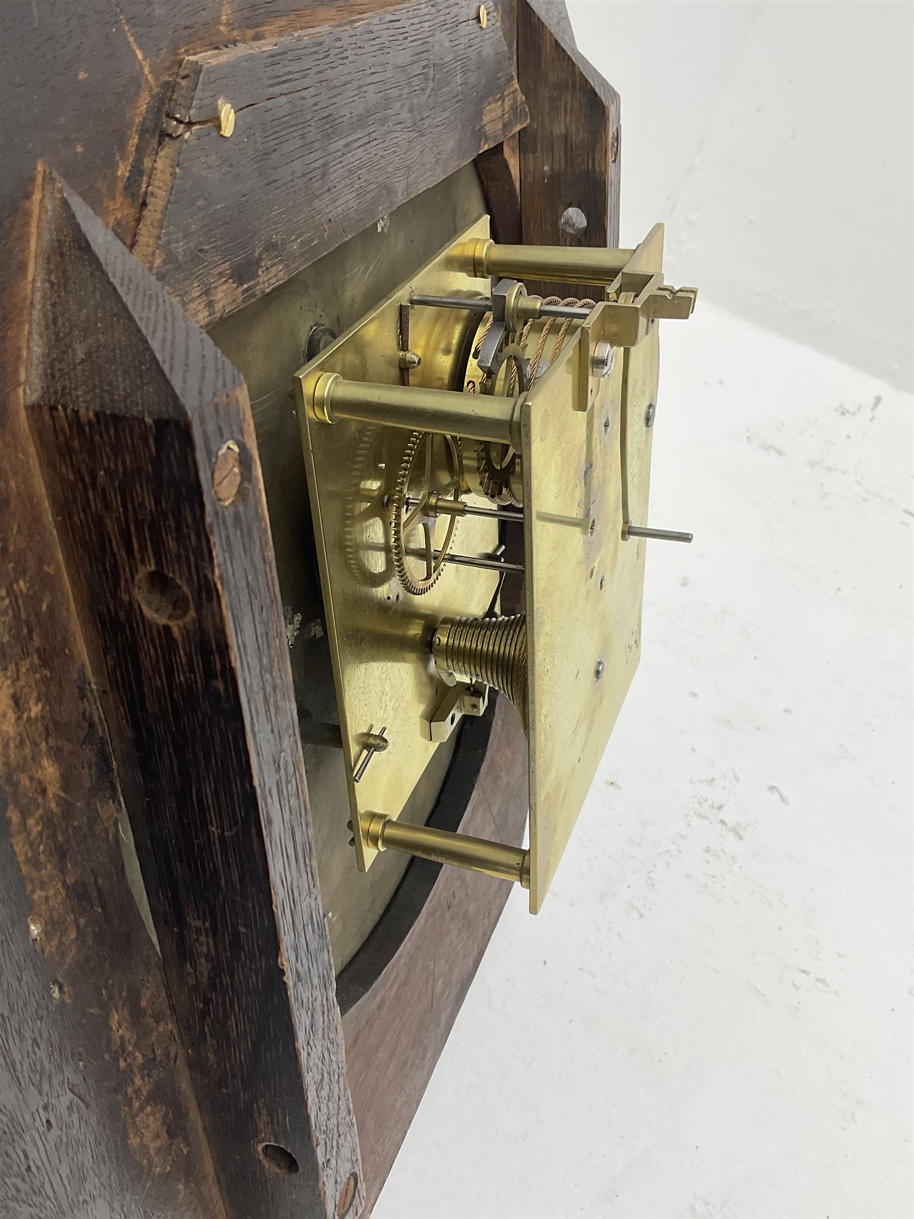 Mid-19th century mahogany veneered eight-day four-pillar single fusee drop dial wall clock with an octagonal dial surround and scroll brass inlay, circular painted steel dial with roman numerals and minute track, matching trefoil steel hands, brass bezel with a flat glass, curved trunk with brass inlaid circles and stringing around the glass pendulum aperture with a brass slip, carved ear pieces in the form of flowers and leaves, with pendulum adjustment door and movement door. With Pendulum & Key