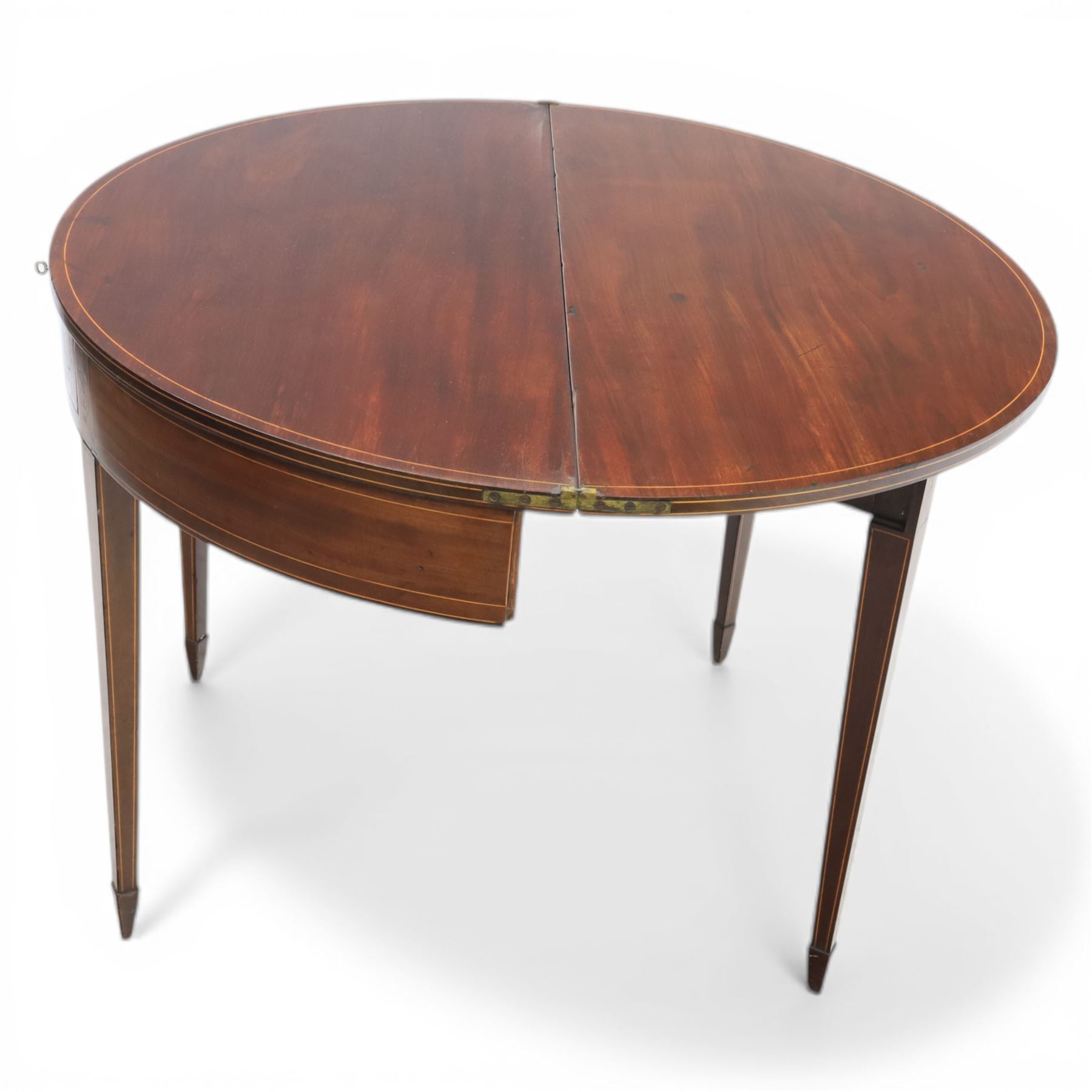 George III Scottish inlaid mahogany demi lune tea table, the curved fold over top opening to reveal a circular top with inlay to edge, above a frieze drawer with key, raised upon tapering inlaid legs with spade feet