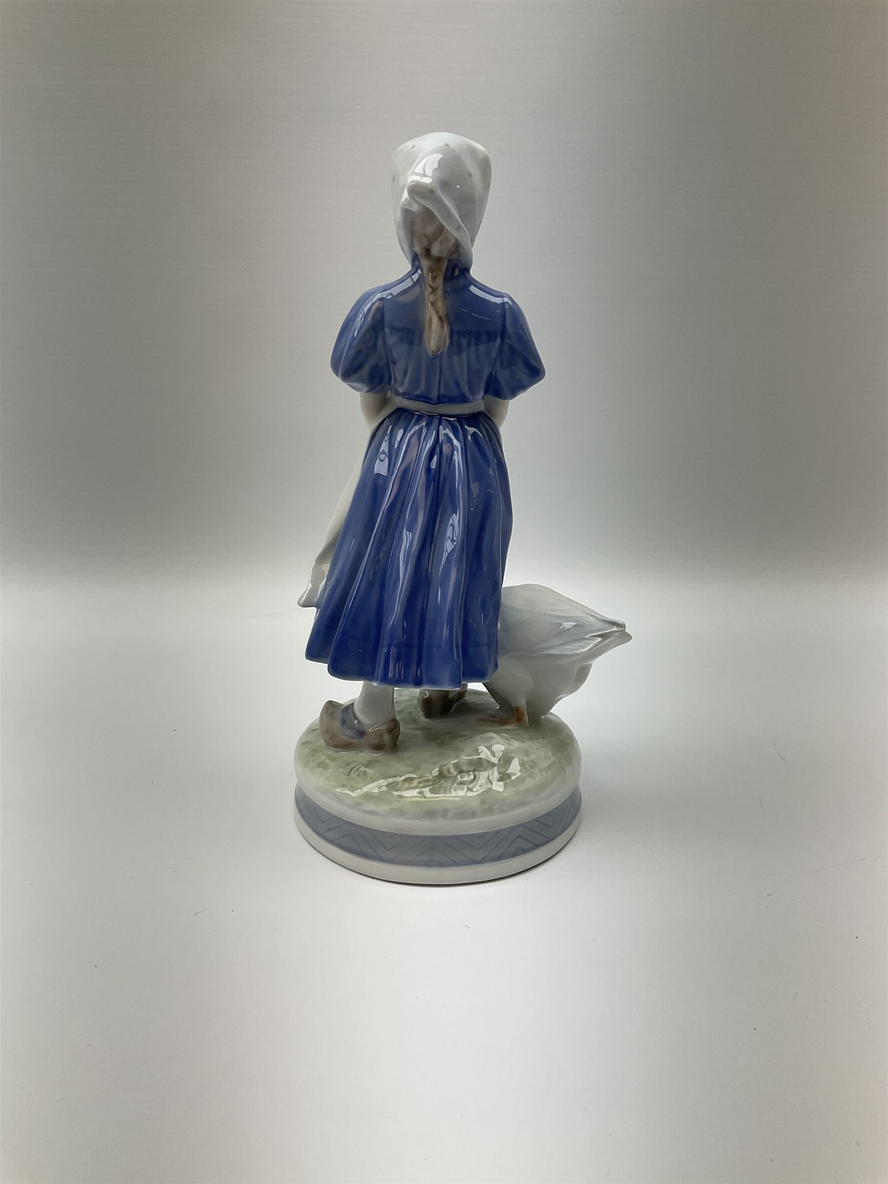 Three  Royal Copenhagen figures, girl knitting 1314, girl standing with a goose 527 and man in traditional Dutch clothing with hammer 620