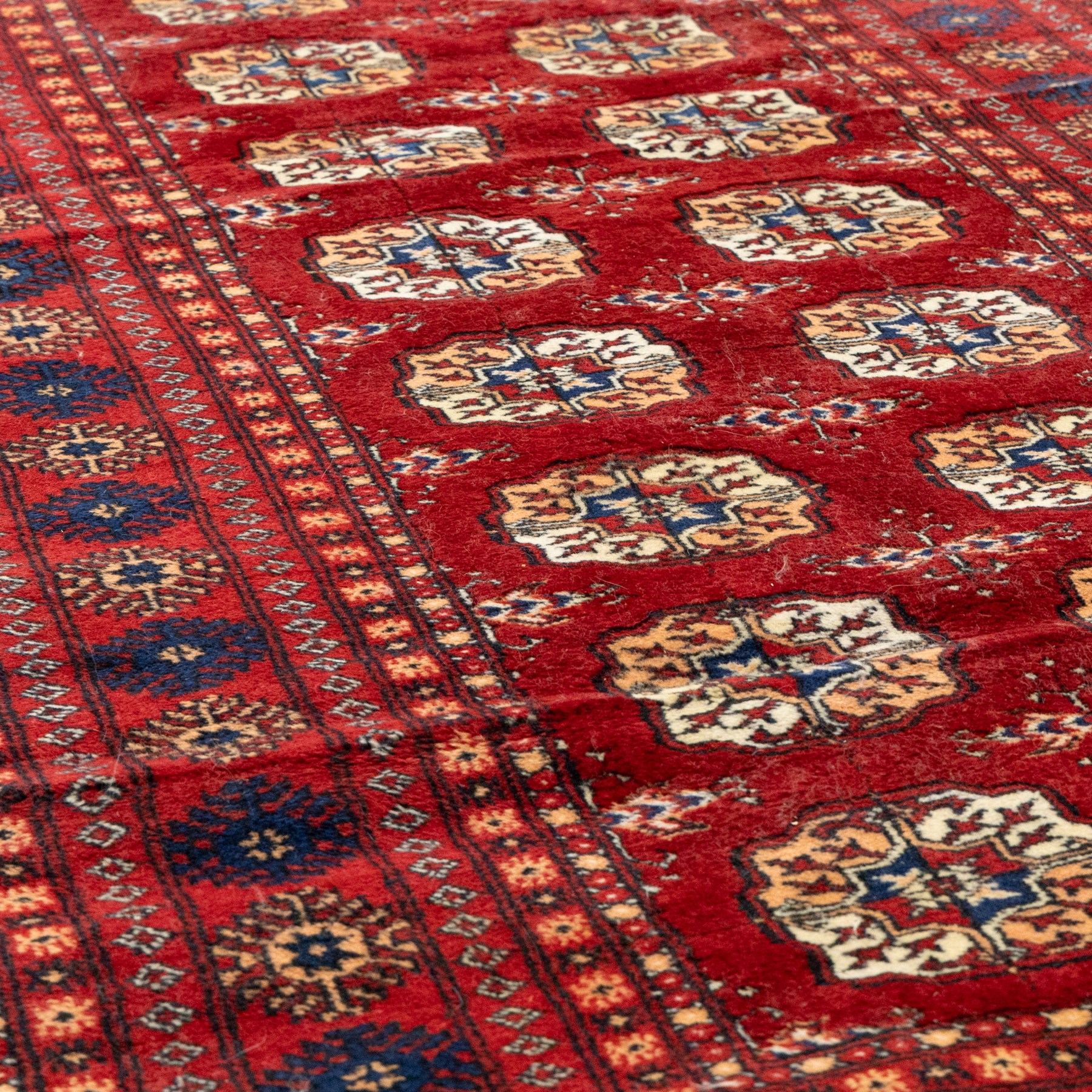 Two hand-knotted rugs, comprising Persian floral rug, dark blue ground decorated with scrolling foliage and flowerheads within a red floral border (H 208cm, W 134cm); Bokhara type rug, red ground with repeating gul motifs and geometric guard borders (H 174cm, W 94cm)