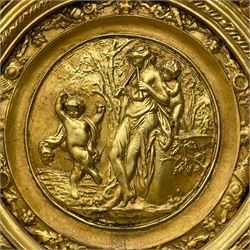 Large Italian Baroque design gilt wall mirror, the shell pediment over circular panel depicting classical female flute player with dancing putto within a tree landscape, the stepped arched upper frame surmounted by musical instrument playing putto and trailing flower heads, central bevelled mirror plate surrounded by plain segmented mirror plates, acanthus leaf moulded outer frame and foliate moulded inner slip