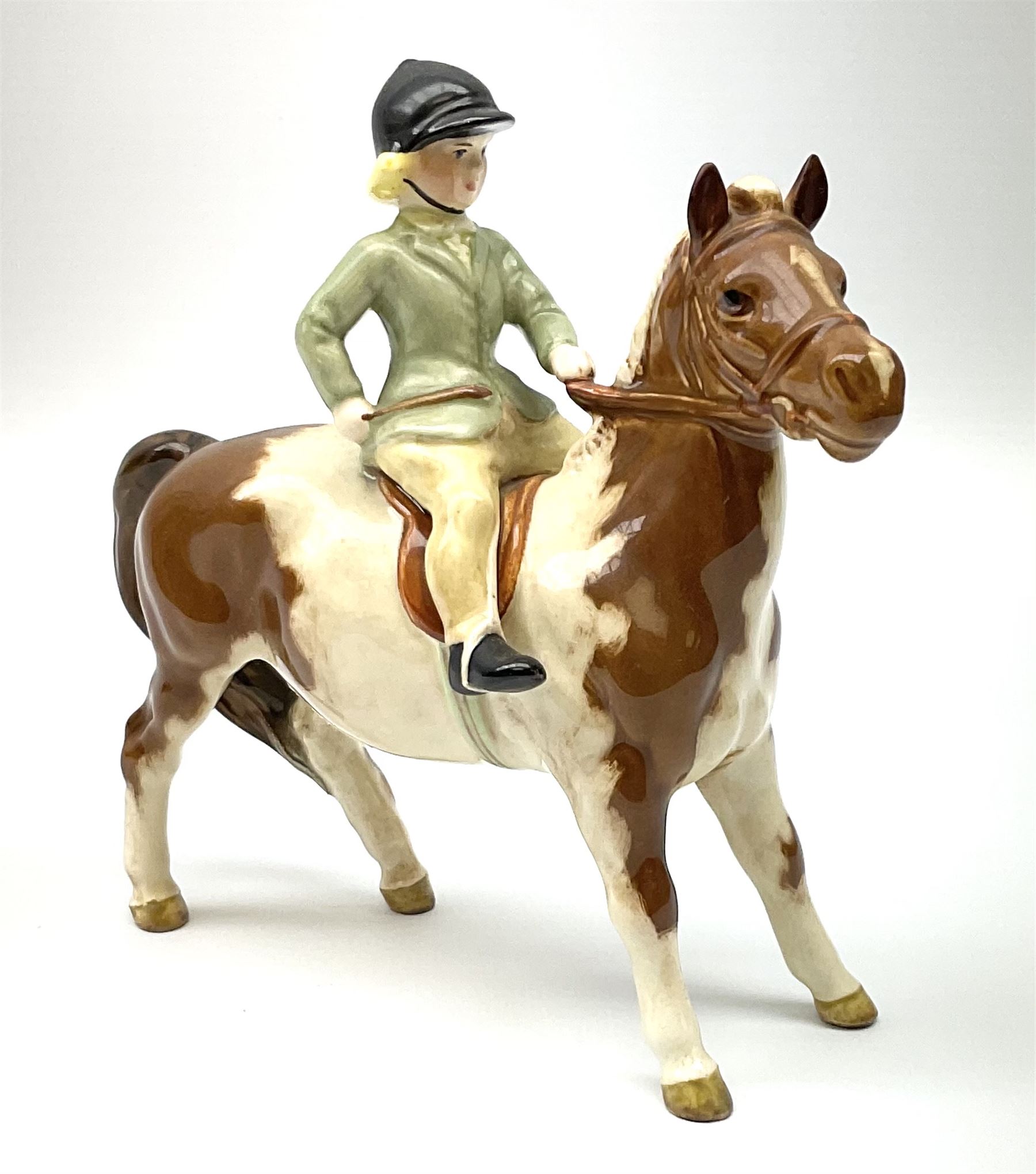 Beswick girl on skewbald pony model no 1499, with printed mark beneath. 