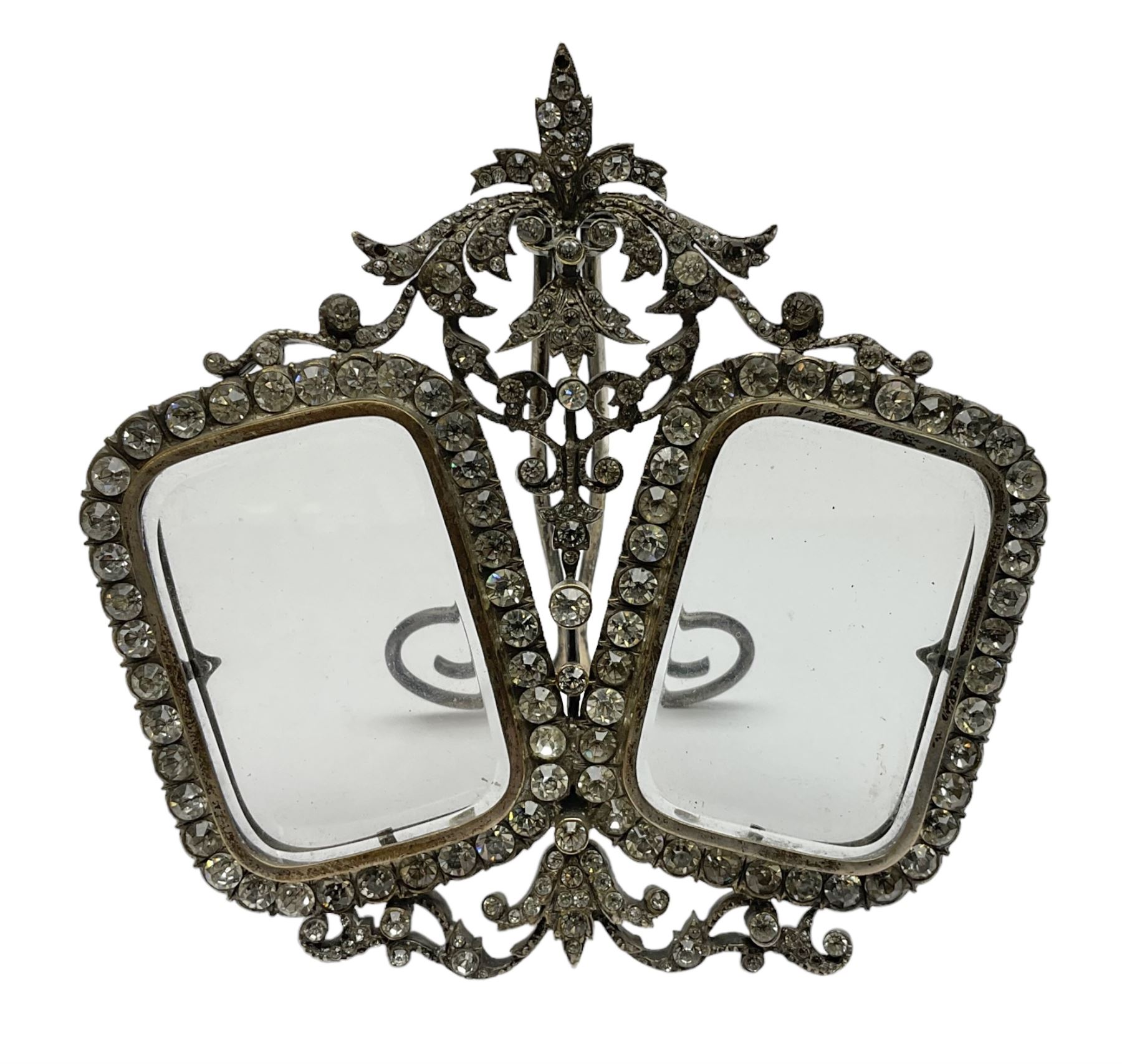 Early 19th century silver plated double photograph frame, each rounded rectangular aperture surrounded by a paste border, with ornate scroll feet and mantling also set with clear paste stones, with easel style support verso, H12cm