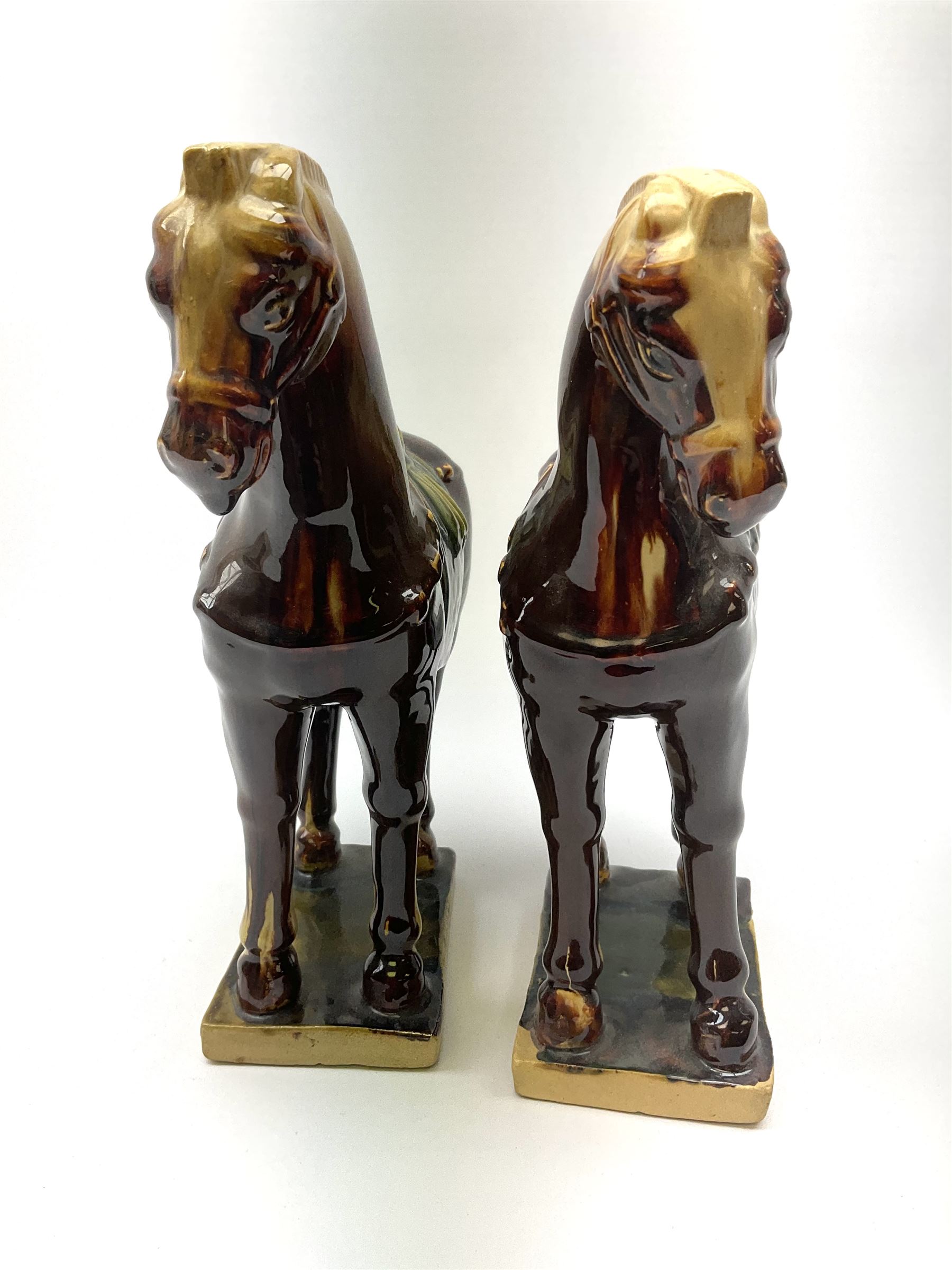 A pair of glazed pottery Tang style horses, each with impressed marks beneath, each approximately H25.5cm. 