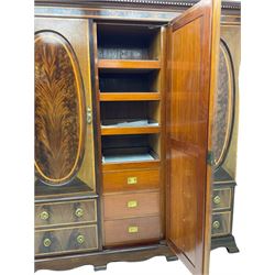 James Shoolbred & Co. London - Edwardian inlaid mahogany triple combination wardrobe, projecting dentil cornice over bevel glazed door, two figured oval panelled doors and four drawers, the central compartment fitted with linen slides and drawers, satinwood banding, on base with shaped apron and bracket feet, with enamel plaque 