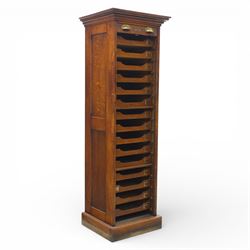 Edwardian oak pedestal office cabinet, moulded rectangular top over tambour shutter enclosing fitted interior, with fifteen graduated drawers each with recessed brass cup handle and label holders, panelled sides, on plinth base