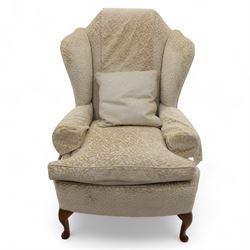 Late 20th century wingback armchair, upholstered in beige embossed fabric with brass stud edging, on cabriole legs and splayed rear legs